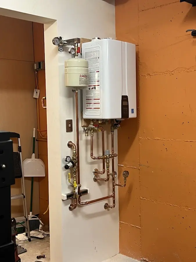 Plumbing technician inspecting water heater connections in Rogersville